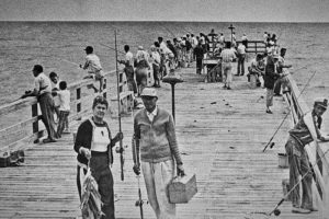 black and white photo of fishermen on the pier